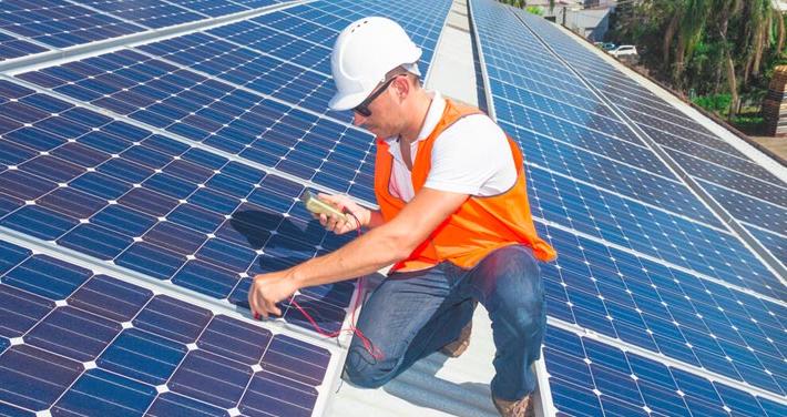 worker checking solar panel